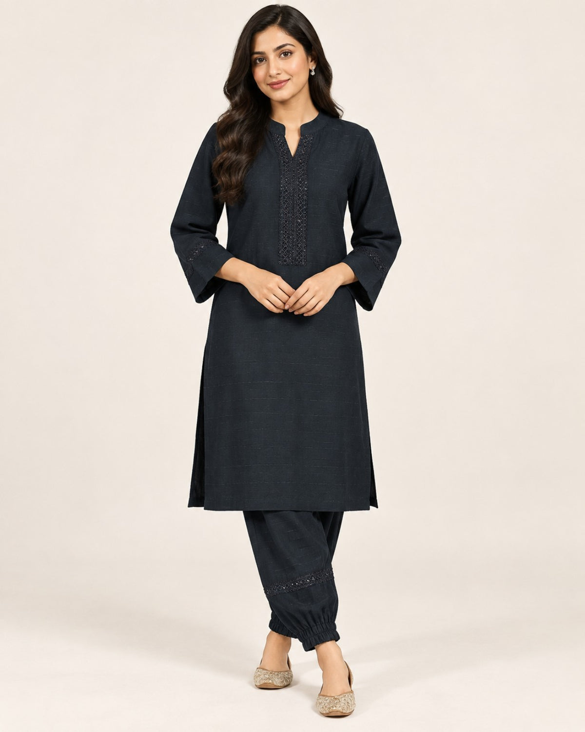 Charcoal kurta with embroidered neckline and three-quarter sleeves, paired with matching gathered-ankle trousers.